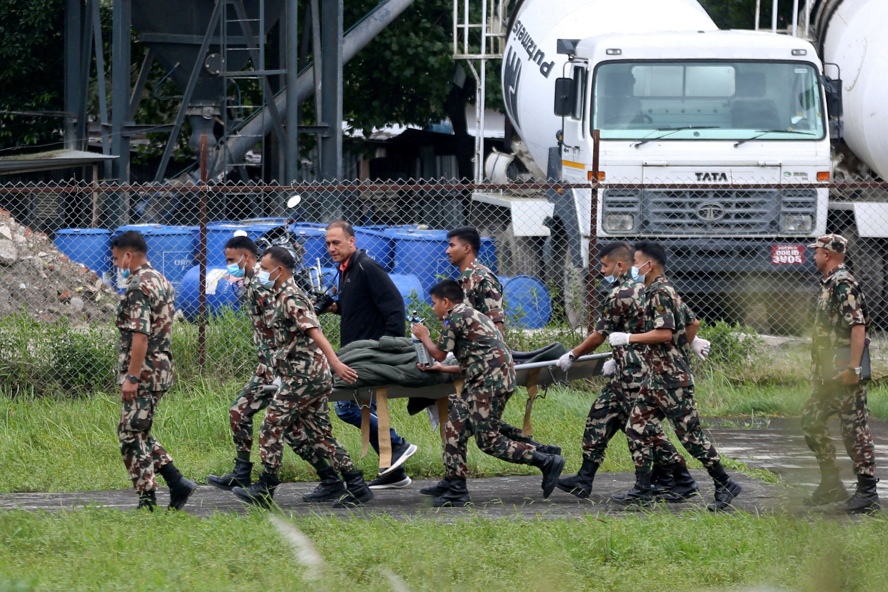Nepal Army soldiers carry Chandika Shrestha, after she was rescued alive from Betrawati, following devastating floods and mudslides, in Kathmandu, Nepal, September 5, 2026.