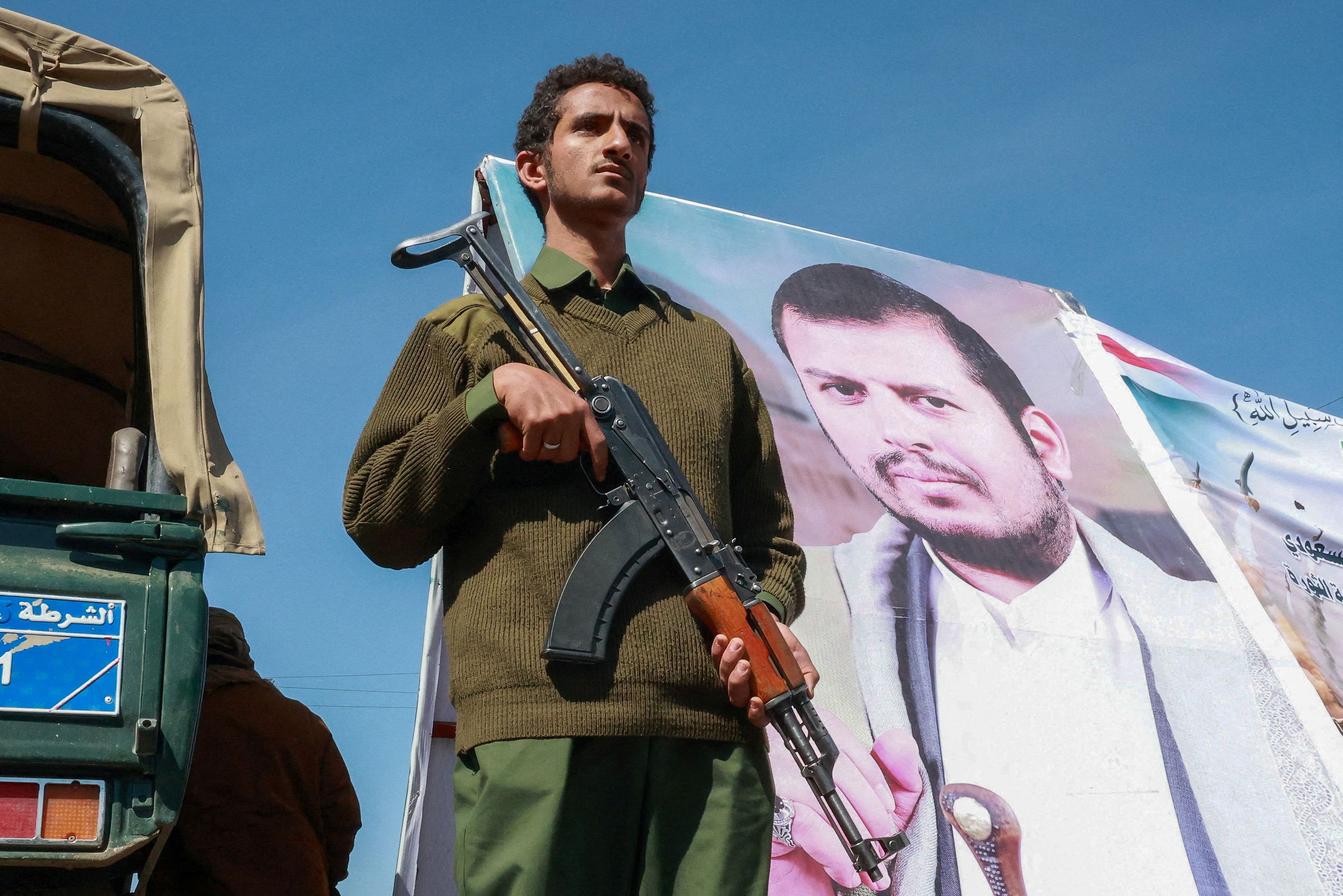 A member of Houthi security forces stands next to a poster of Houthi leader Abdul-Malik al-Houthi at the site of a gathering of Houthi supporters to show solidarity with the movement as fighting intensifies across several fronts, in Sanaa, Yemen October 7, 2026.