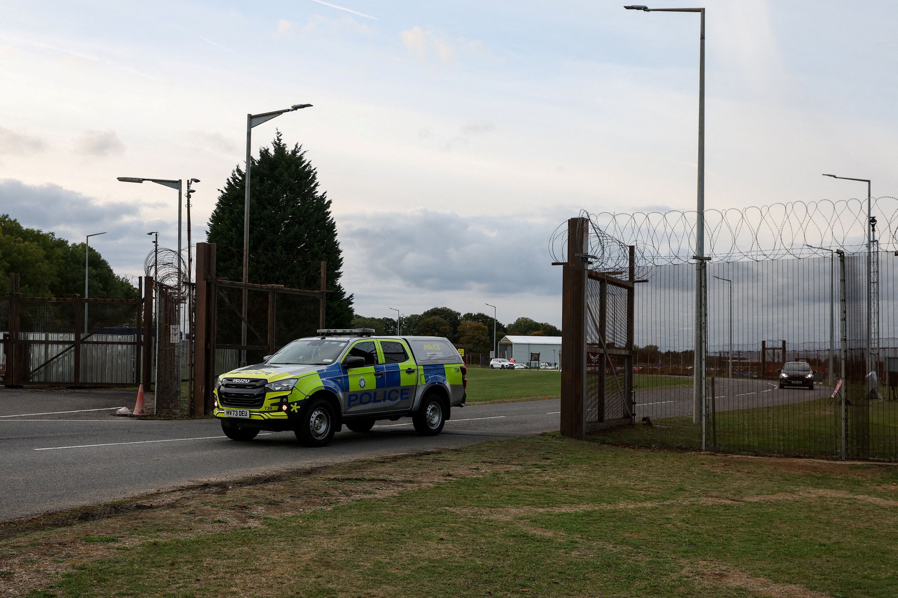 A police car leaves RAF Molesworth after two Latvian nationals were arrested on suspicion of entering a prohibited place, in Cambridgeshire, Britain, October 8.