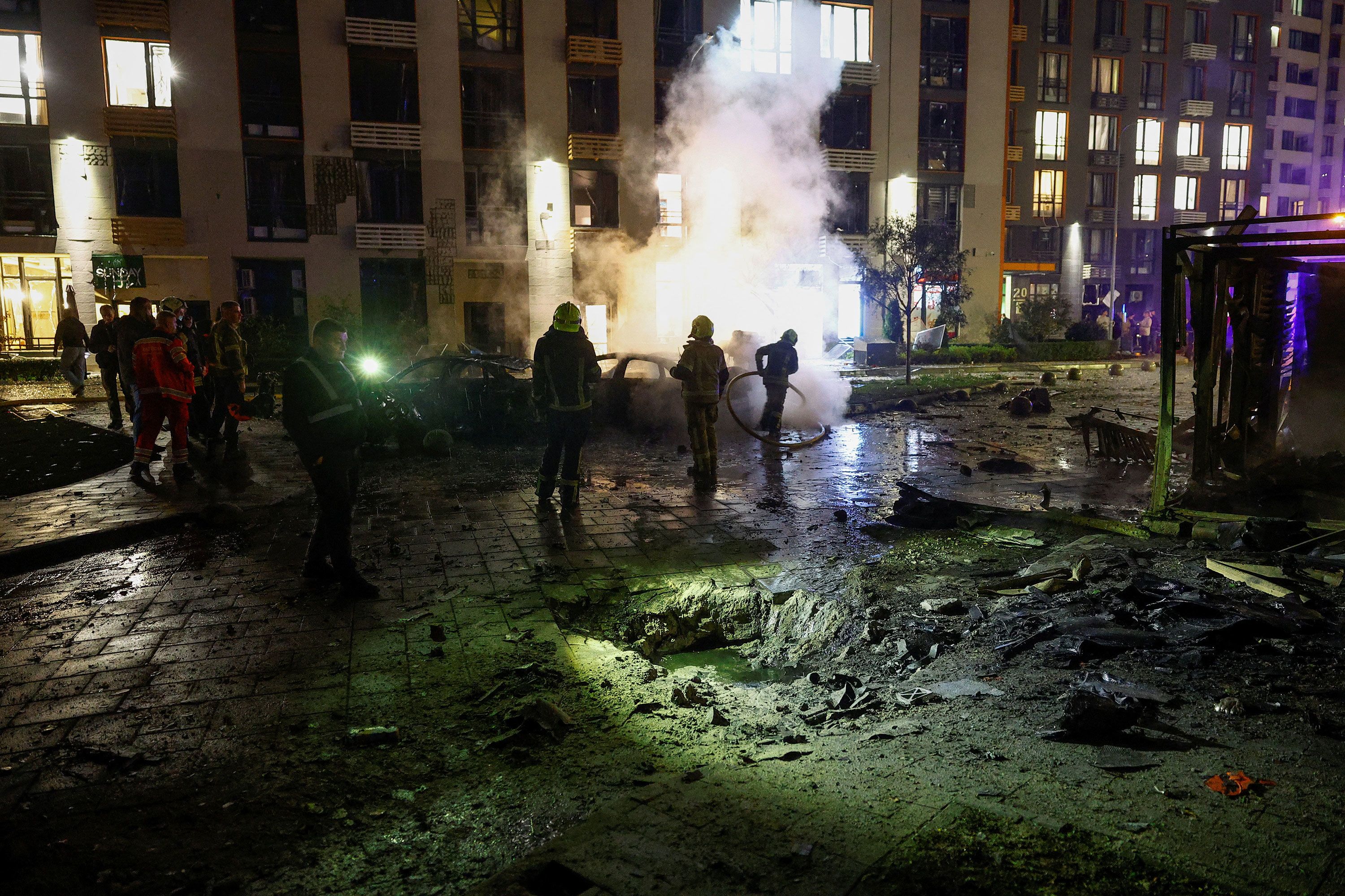 Emergency employees work at the site of a residential area damaged during a Russian drone strike, amid Russia's attack on Ukraine, in Kyiv, Ukraine October 12, 2026. REUTERS/Valentyn Ogirenko