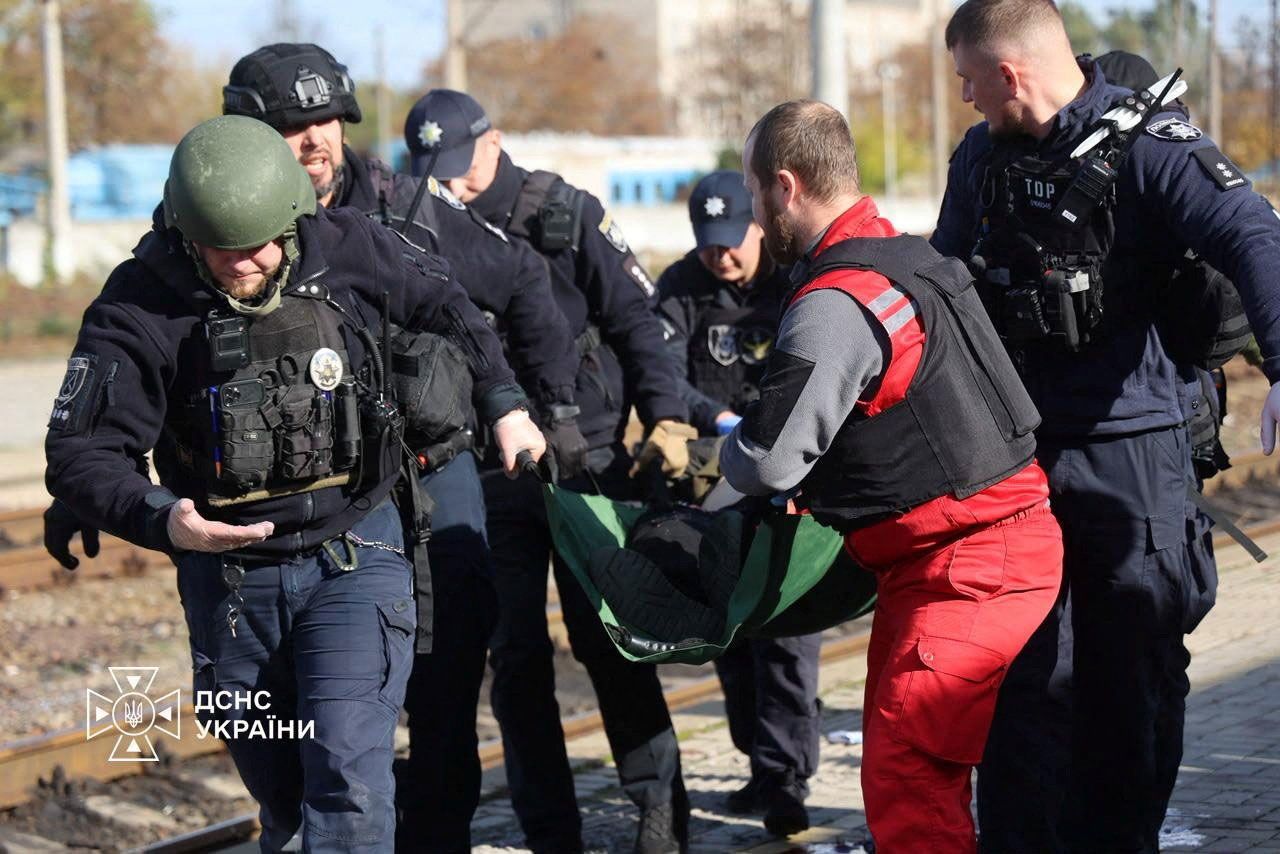 A paramedic and police officers carry a person injured at a railway station during a Russian drone strike, amid Russia's attack on Ukraine, in Dnipro Thursday.